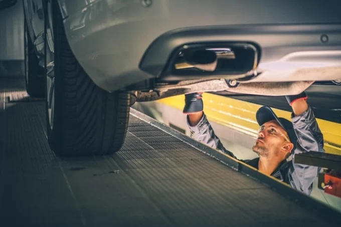 Mechanic inspecting vehicle undercarriage on a lift at our Oklahoma City transmission shop